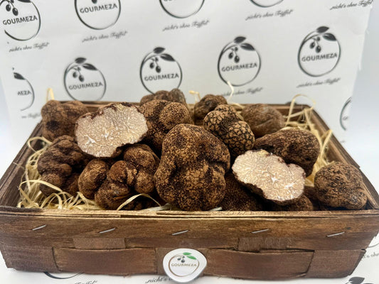 Frische Tuber indicum Trüffel in einer Holzkiste, zwei davon aufgeschnitten